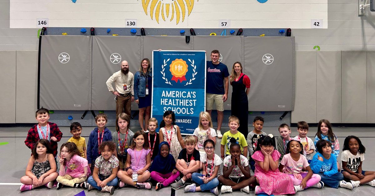 group of students sitting around banner